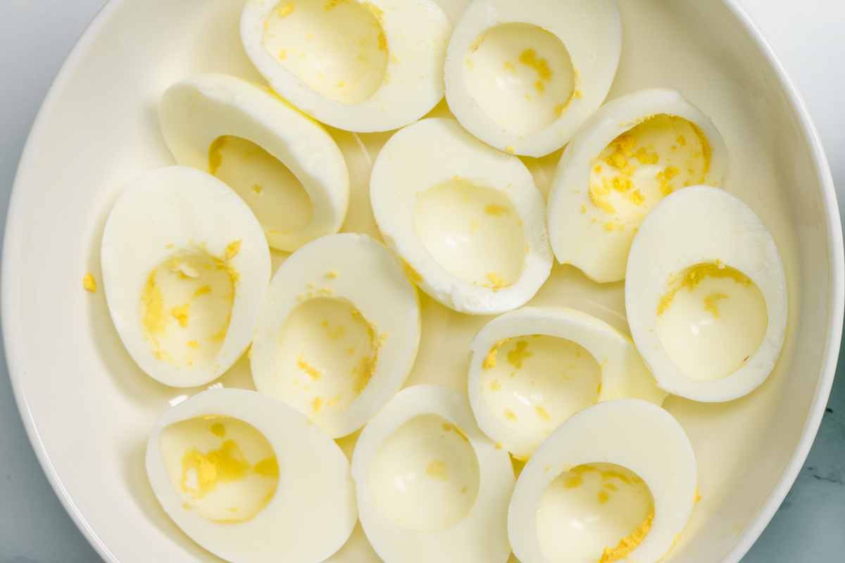 Hard boiled egg white halves with no egg yolks in a white bowl.